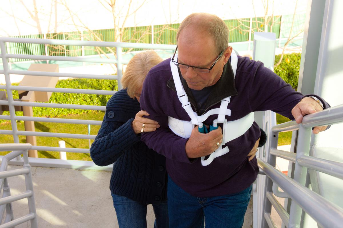 Man wearing Heart Hugger, walking up stairs.