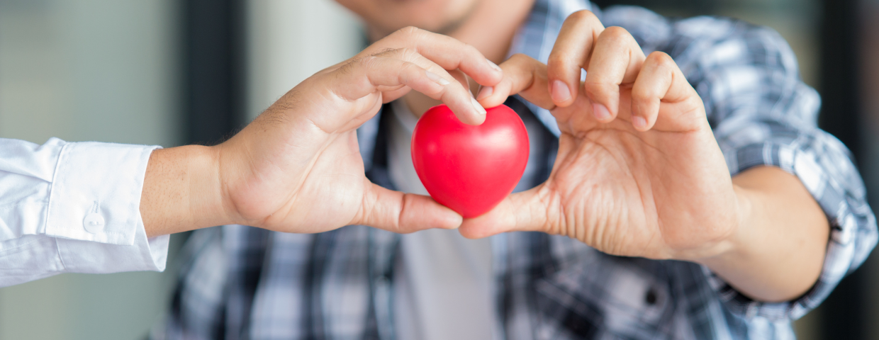 Patient and doctor holding a red heart toy, symbolizing the idea that both patients and doctors have what is best in mind for heart health and heart surgery recovery