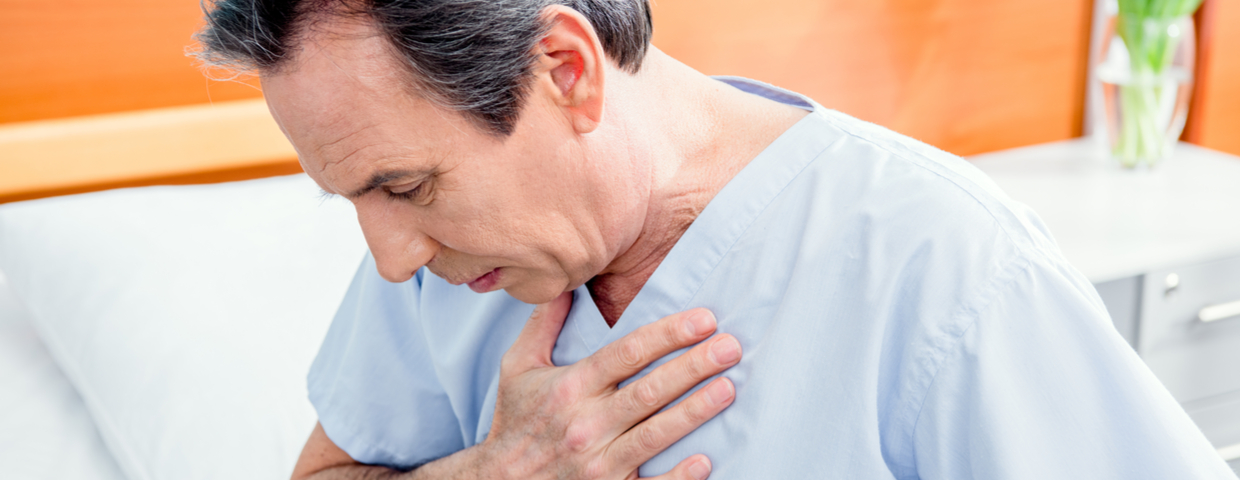 Patient Clutches His Chest in Hospital Bed