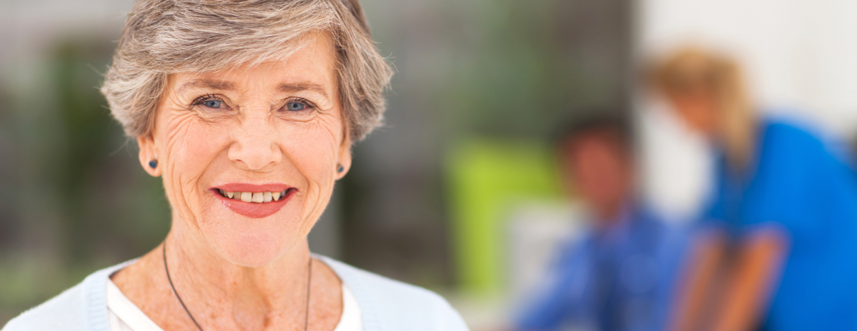 Smiling Heart Hugger Patient with Medical Professionals in Back